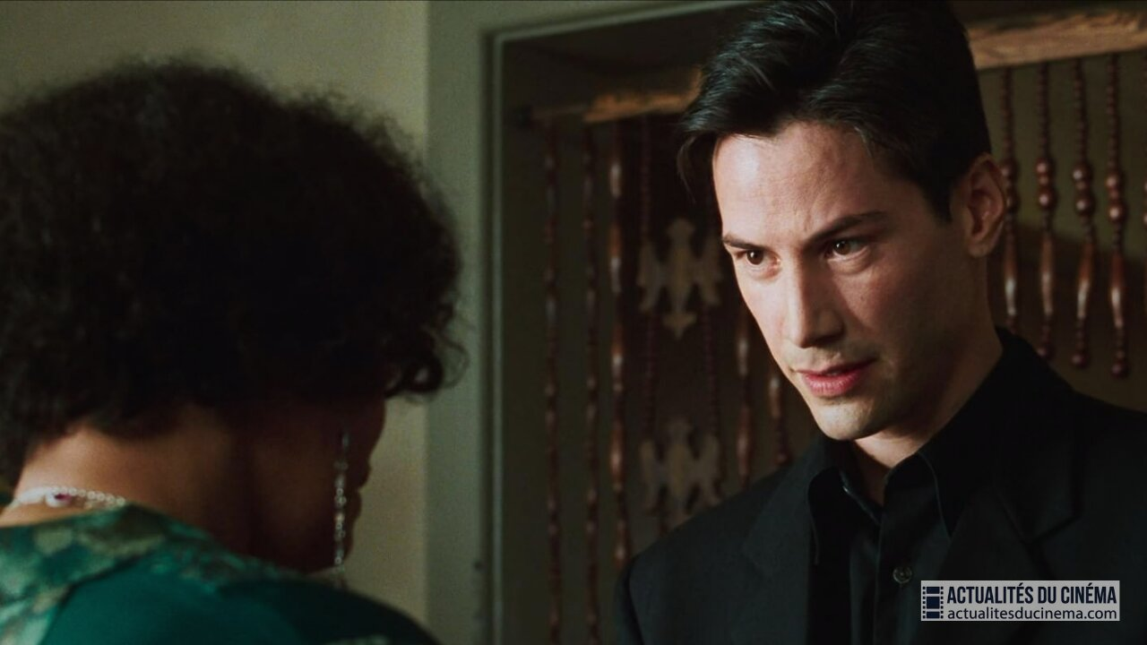 Neo et l'Oracle discutent dans la cuisine.